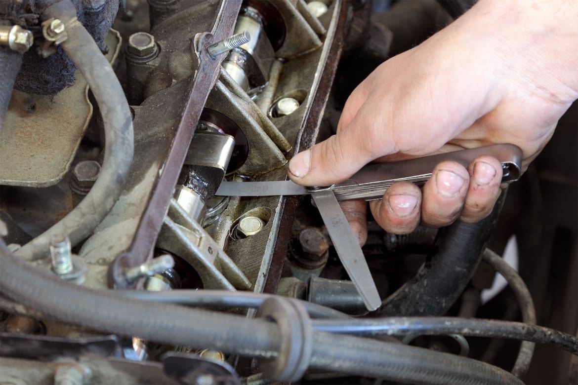 A valve clearance adjustment being performed on a car