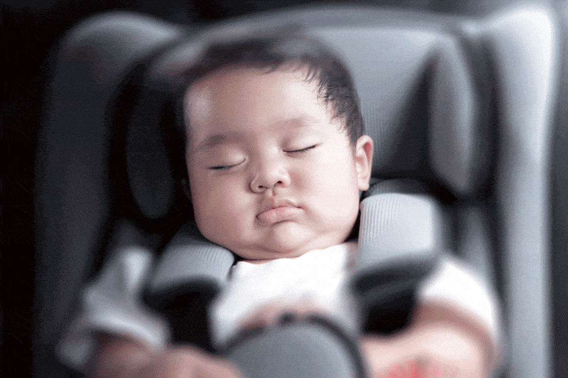 A baby sleeping in a child car seat
