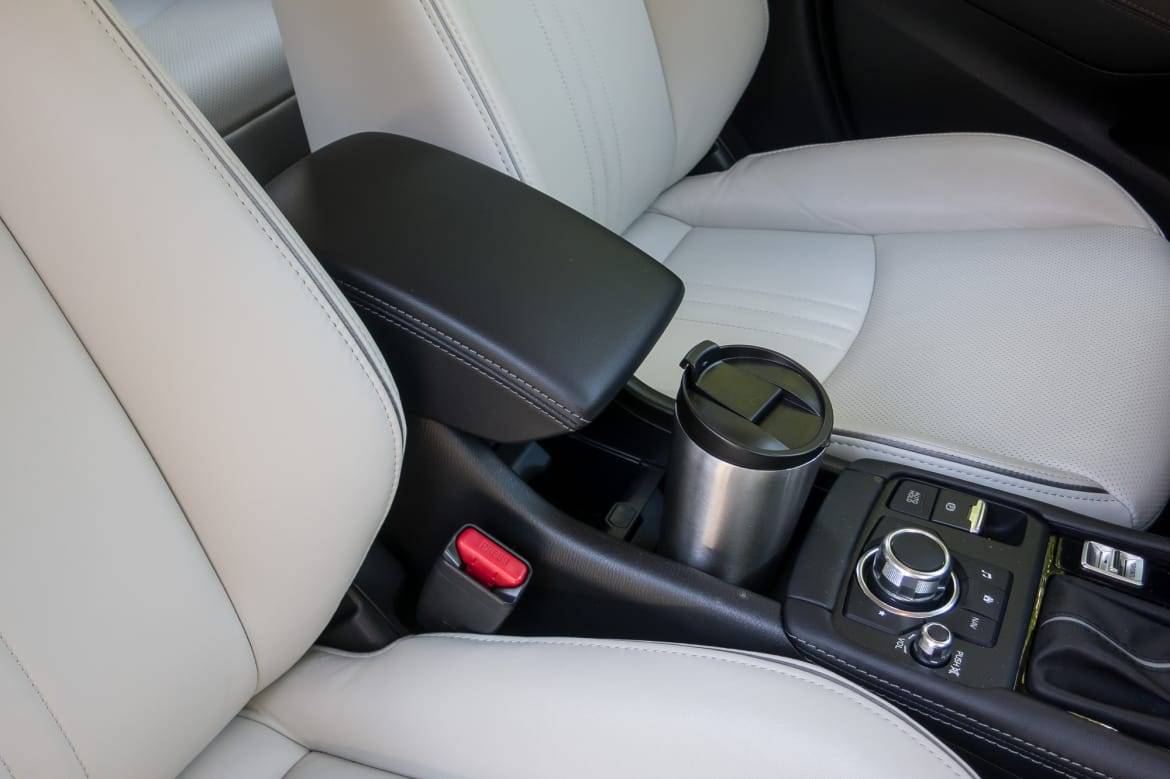 A new center console now has storage and one cupholder that's usable with the armrest down. | Cars.com photo by Fred Meier