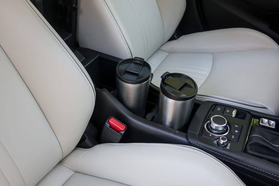 Using both front cupholders still requires raising the armrest. | Cars.com photo by Fred Meier